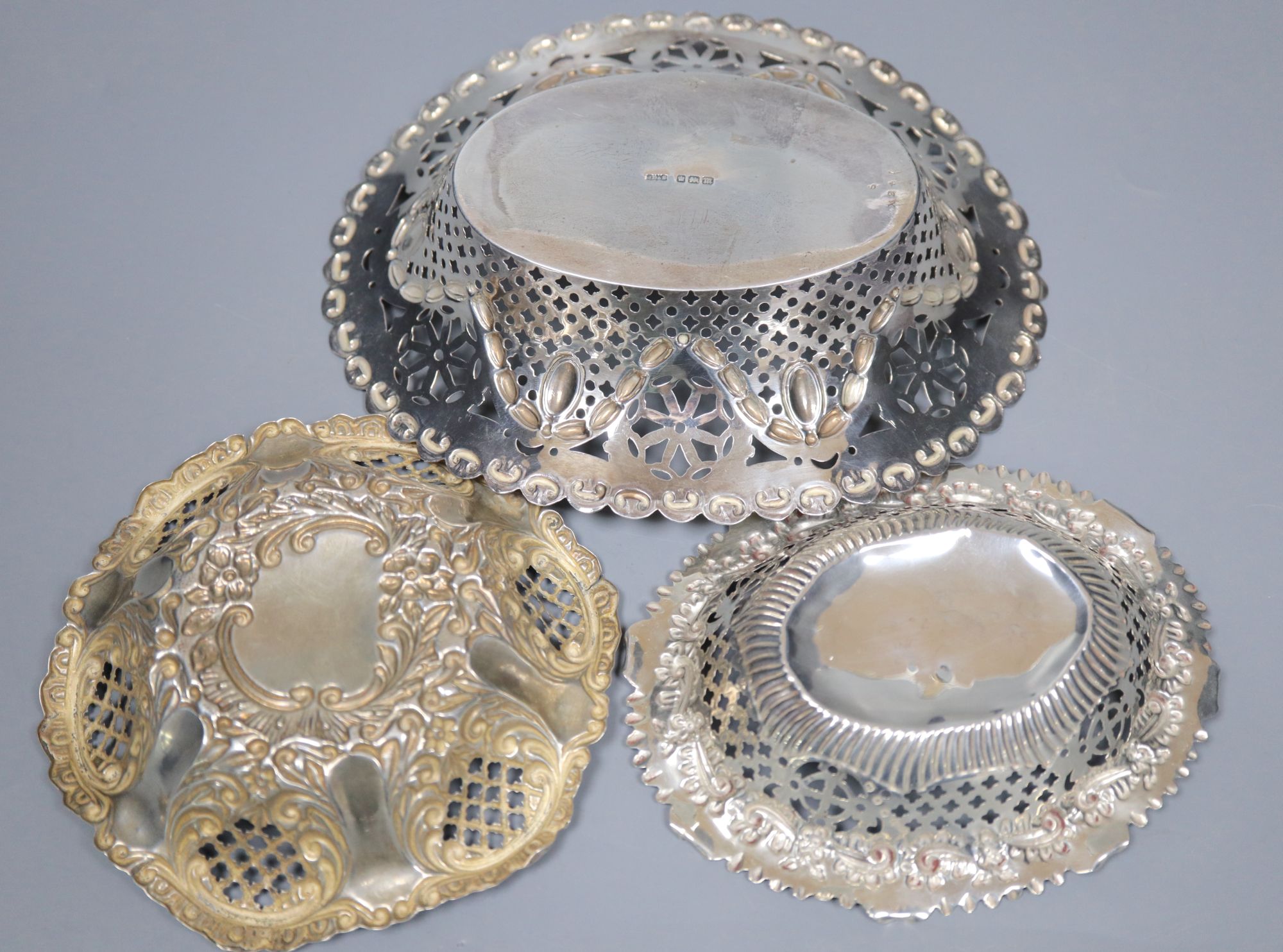 A late Victorian repousse silver bon bon dish and two similar Edwardian dishes, largest 16.8cm, 159 grams.